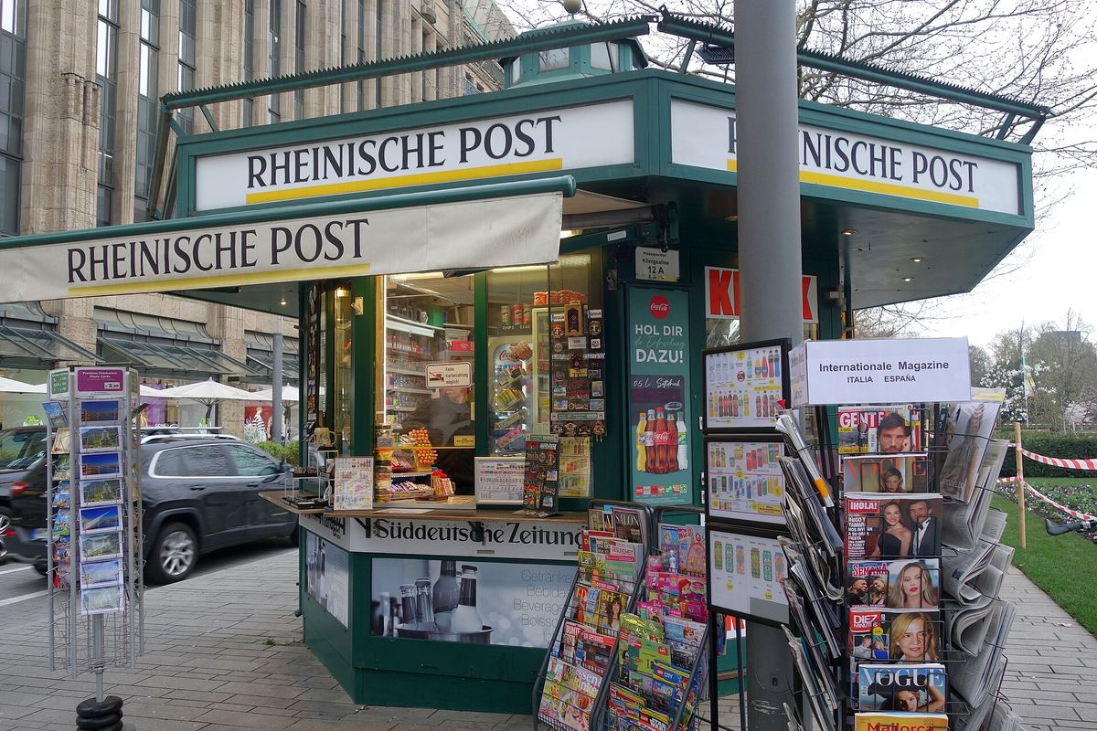 Zeitungskiosk mit Schriftzug einer Regionalzeitung und Zeitschriftenständern